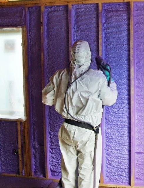 photo of worker spray foaming a residential build
